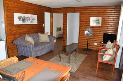 a living room with a couch and a table at Trout Ways in Waterval Boven