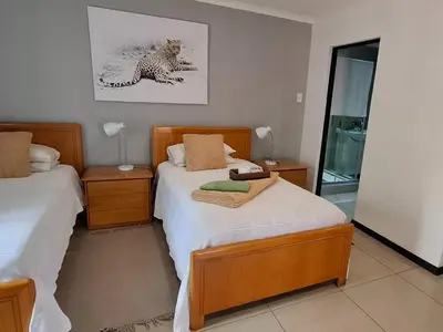 a bedroom with two beds and a picture of a leopard at Green Haven Guest Lodge in Pretoria