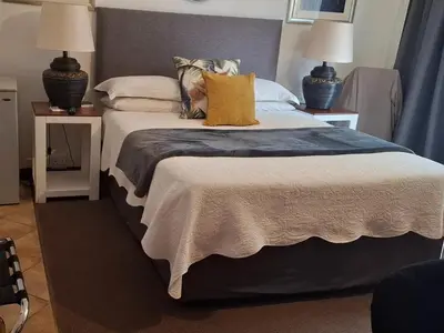 a bedroom with a large bed with two lamps at Green Haven Guest Lodge in Pretoria