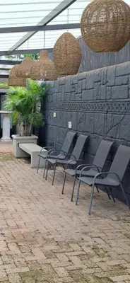 a group of chairs are lined up against a wall at Green Haven Guest Lodge in Pretoria