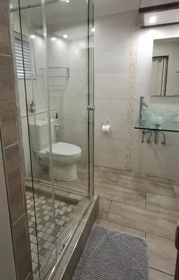 a bathroom with a shower with a toilet and a sink at Green Haven Guest Lodge in Pretoria