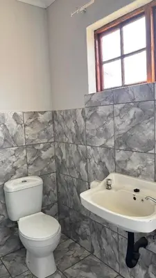 a bathroom with a toilet and a sink at The N1 Farm Place in Pretoria