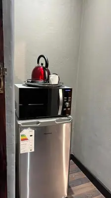 a microwave sitting on top of a refrigerator at The N1 Farm Place in Pretoria