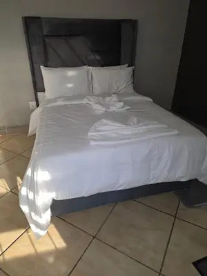 a large white bed with white sheets and pillows at The Good Samaritan 4 in Witbank