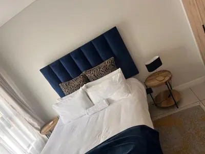 a bed with a blue headboard in a room at Kaso holidays in Pretoria