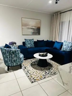 a living room with a blue couch and a table at Kaso holidays in Pretoria