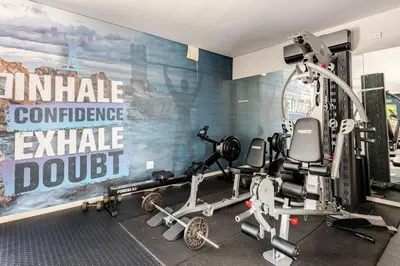 a gym with tread machines and a wall mural at Spacious Executive Luxury Apartment in Midrand