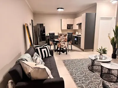 a living room with a couch and a table at Spacious Executive Luxury Apartment in Midrand