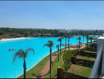 a view of a large swimming pool with palm trees at Blyde Lagoon View Facing Crystal 2 Large Bedrooms in Pretoria