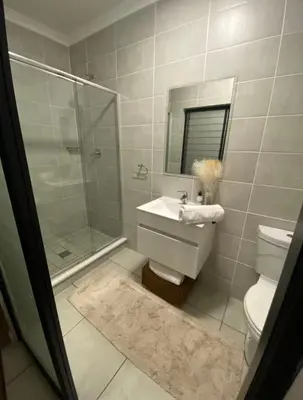 a bathroom with a toilet and a sink and a shower at Blyde Lagoon View Facing Crystal 2 Large Bedrooms in Pretoria