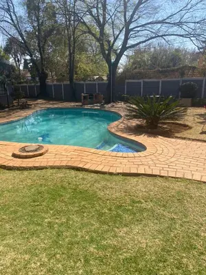 a swimming pool in a yard with a brick patio at 39 Maple in Pretoria