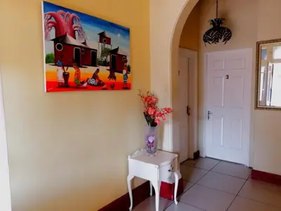 a vase of flowers on a table in a hallway at 39 Maple in Pretoria