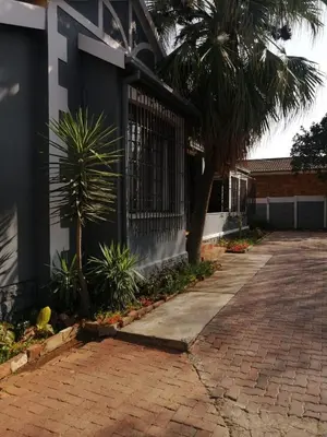 a brick sidewalk next to a building with a gate at 39 Maple in Pretoria