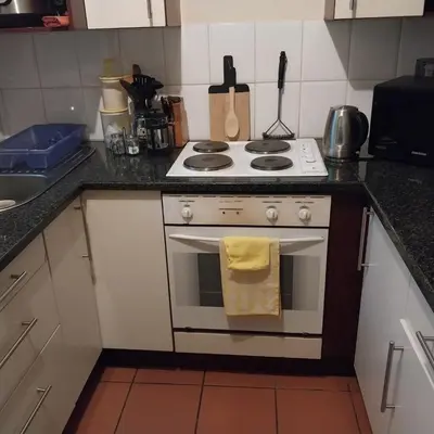 a kitchen with a stove with a yellow towel on it at Travellor's relaxation unit, secure 1,5 bedrooms in Sandton