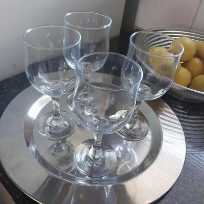 four wine glasses sitting on a plate on a table at Travellor's relaxation unit, secure 1,5 bedrooms in Sandton