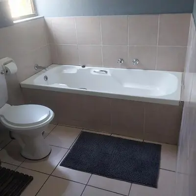 a bathroom with a white tub and a toilet at Travellor's relaxation unit, secure 1,5 bedrooms in Sandton