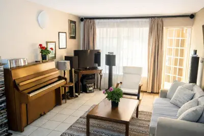 a living room with a piano and a couch at Lafenis in Pretoria