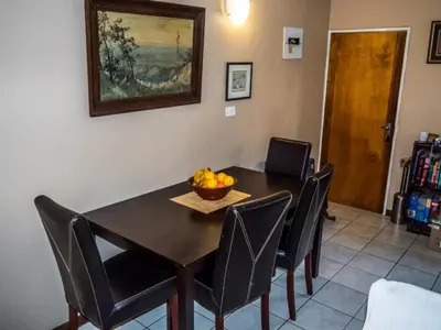 a dining room table with chairs and a bowl of fruit on it at Lafenis in Pretoria