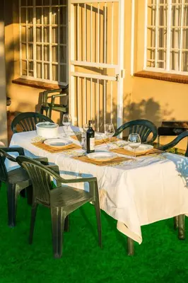 a table with chairs and a white table cloth on it at Lafenis in Pretoria