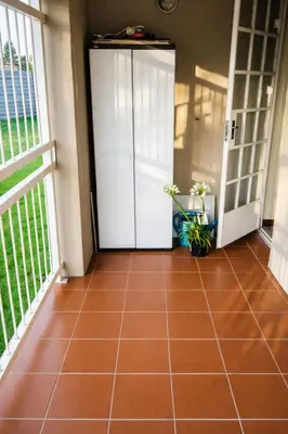 a hallway with a white door and a tile floor at Lafenis in Pretoria