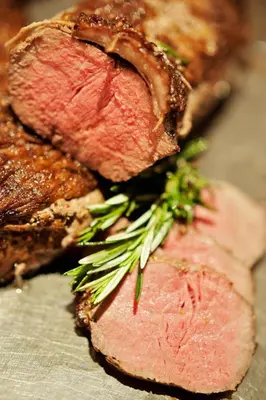 a close up of two slices of meat with greens on it at Premier Hotel Pretoria in Pretoria