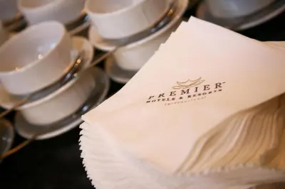 a pile of cups and saucers with a napkin at Premier Hotel Pretoria in Pretoria
