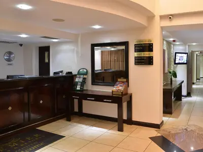 a waiting room with a desk and a mirror at Premier Hotel Pretoria in Pretoria