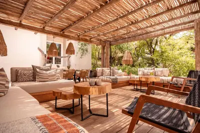 an outdoor living room with a wooden pergola at Kapama Karula in Kapama Private Game Reserve