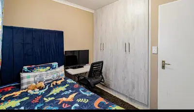 a bedroom with a bed with a desk and a computer at River luxury home in Chartwell