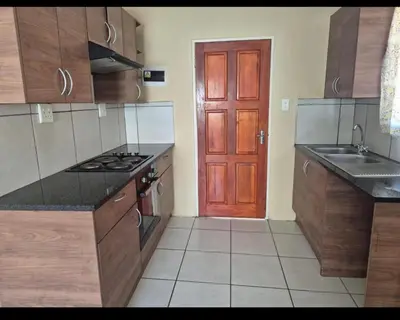 a kitchen with a red door and wooden cabinets at River luxury home in Chartwell