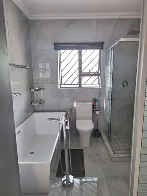 a bathroom with a tub and a toilet and a shower at Sunrise Lodge in Phalaborwa