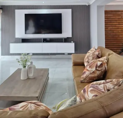 a living room with two couches and a tv at Sunrise Lodge in Phalaborwa