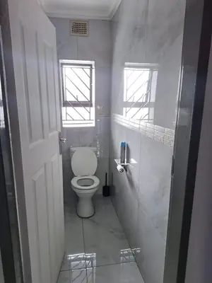 a bathroom with a toilet and a walk in shower at Sunrise Lodge in Phalaborwa