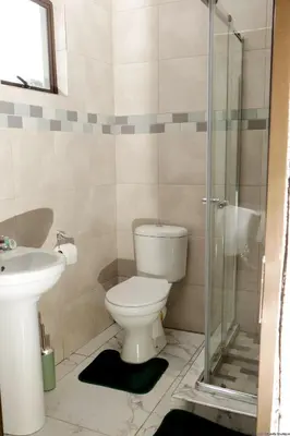 a bathroom with a toilet and a glass shower at Siyamthanda Boutique in Louis Trichardt