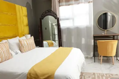 a bedroom with a large bed and a mirror at Siyamthanda Boutique in Louis Trichardt