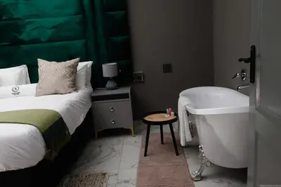 a bedroom with a bed and a bath tub next to a sink at Siyamthanda Boutique in Louis Trichardt