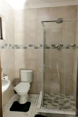 a bathroom with a shower with a toilet and a sink at Siyamthanda Boutique in Louis Trichardt