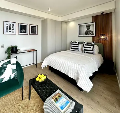 a bedroom with a large white bed and a couch at Explore Ellipse - The Sage Apartment in Midrand