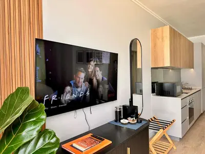 a living room with a large flat screen tv on a wall at Explore Ellipse - The Sage Apartment in Midrand