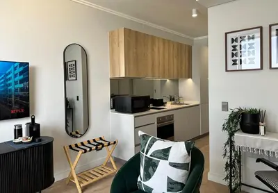 a living room with a couch and a kitchen at Explore Ellipse - The Sage Apartment in Midrand