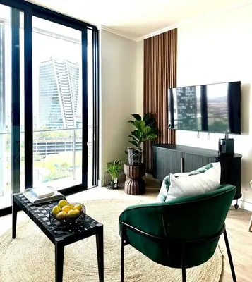 a living room with a green chair and a table at Explore Ellipse - The Sage Apartment in Midrand