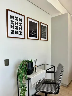 a living room with a glass table and a chair at Explore Ellipse - The Sage Apartment in Midrand