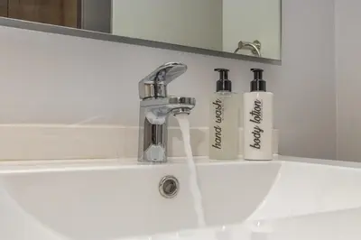 a bathroom sink with two soap bottles on it at Ellipse Soleya in Midrand