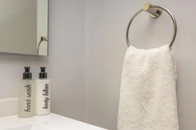 a white towel hanging on a wall next to a sink at Ellipse Soleya in Midrand