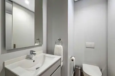a white bathroom with a sink and a toilet at The Solace in Midrand