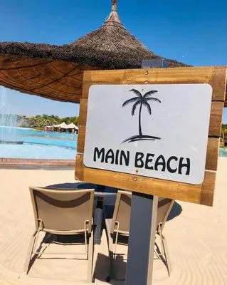 a sign on the beach with two chairs and a palm tree at The Blyde Crystal Lagoons in Pretoria