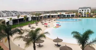 a large swimming pool with umbrellas and palm trees at The Blyde Crystal Lagoons in Pretoria