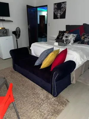 a bedroom with a bed with a couch with pillows at Sbarba guesthouse in Ga-Kgapane
