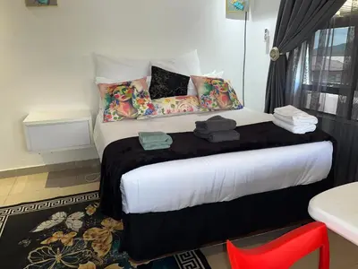 a bedroom with a large bed with pillows at Sbarba guesthouse in Ga-Kgapane