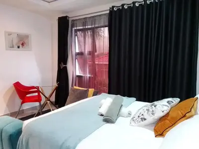 a bedroom with a bed and a window with black curtains at Sbarba guesthouse in Ga-Kgapane